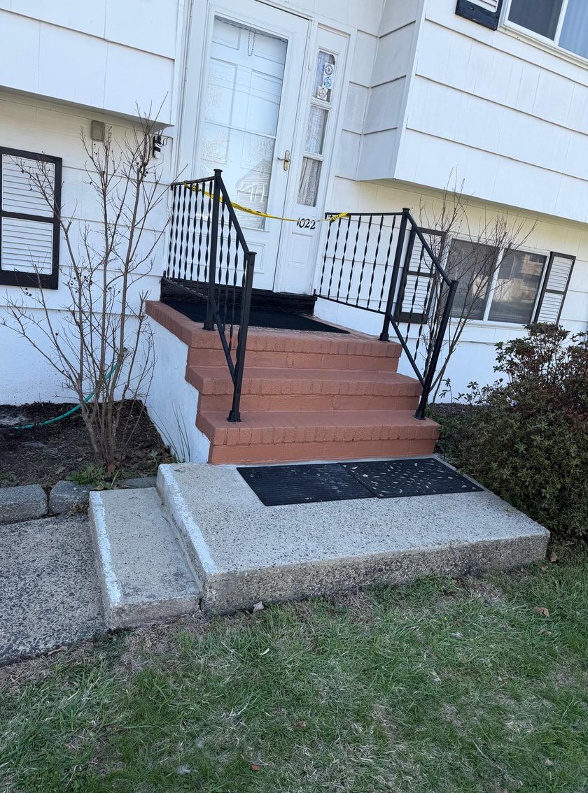 Repainted terracotta front steps with new black wrought-iron railings