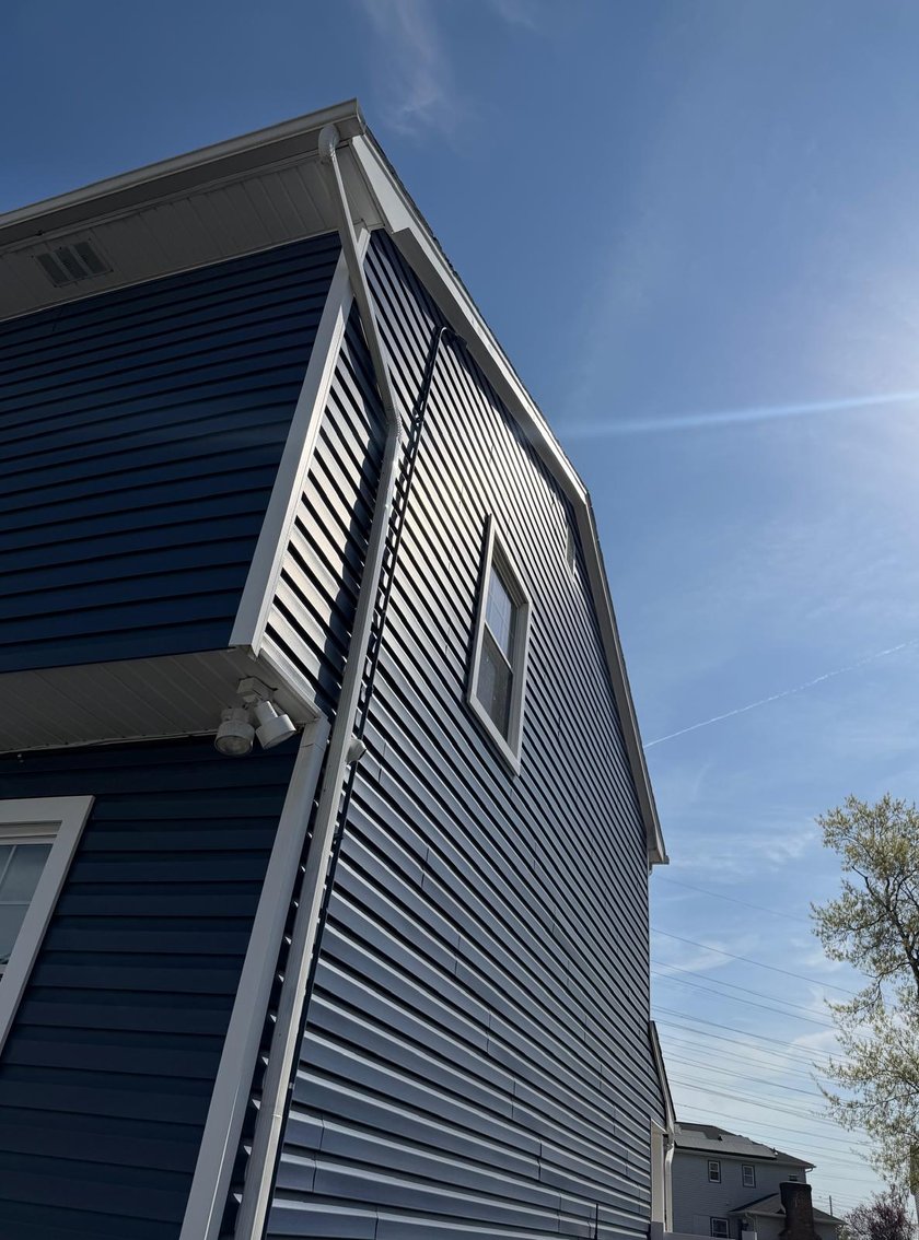 Two-story home with new navy blue vinyl siding